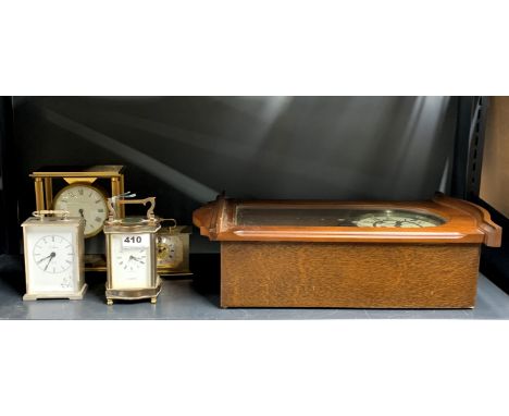 A brass carriage clock together with four further clocks.