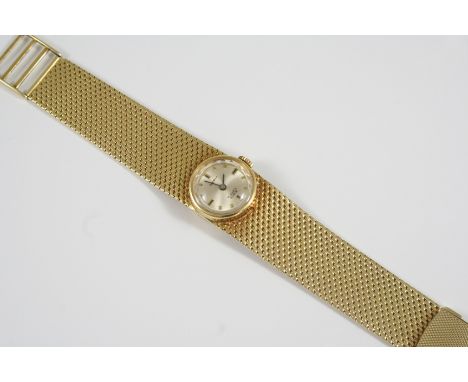 A LADY'S 14CT. GOLD WRISTWATCH the circular dial with baton numerals, on an integrated woven link bracelet with ladder clasp,