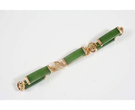 A JADE AND GOLD BRACELET formed with sections of jade in 14ct. gold mounts, 20cm. long.