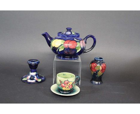 MOORCROFT TEAPOT in the Plum Wisteria design, also with a small Pomegranate vase, a candlestick in the Pansy design, and a cu