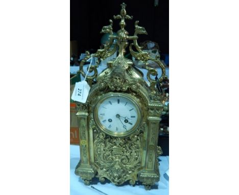 French Japy Frere-style gilt brass mantel clock with ornate foliate scroll and mask decoration, the enamel dial flanked by co