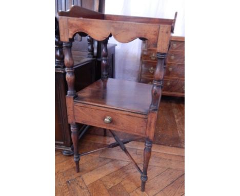 An early 19th century mahogany washstand, the top with splash surround and receptacles for beakers and bowls, a shelf and fri