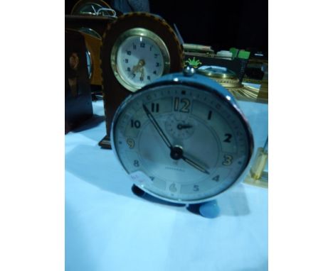 An Ingersoll alarm clock and a small mahogany domed cased mantel clock