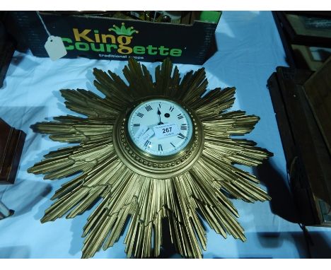A carved sunburst gilt framed wall clock, box with enamel dial, and roman numerals and french movement, dia. 45cm