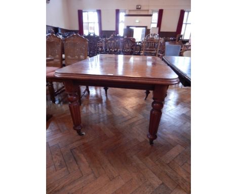 A Victorian mahogany dining table, with moulded edge top, and extra leaf, and turned reeded tapering legs with ceramic castor