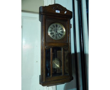 Oak hanging wall clock with glazed panelled door 