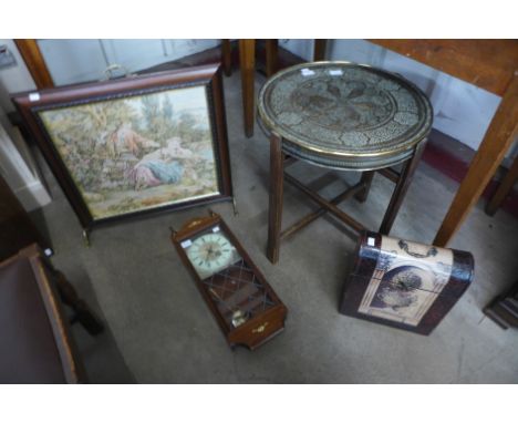 An oak wall clock, a folding brass topped occasional table, a fire screen and a wine bottle carrier 