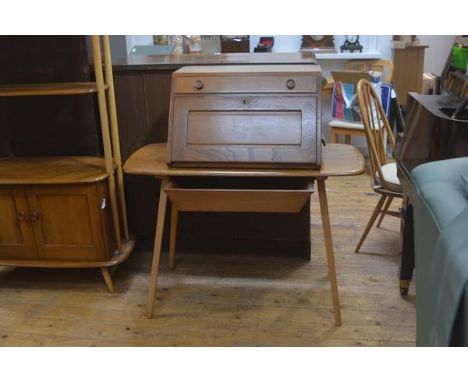 An Ercol light elm bureau desk, the freestanding secretaire top with single frieze drawer above a fall front with twin scroll