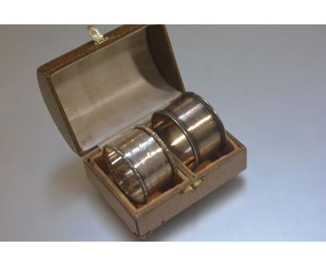A domed casket with velvet lined interior, a Birmingham silver engine turned napkin ring and a white metal engraved napkin ri