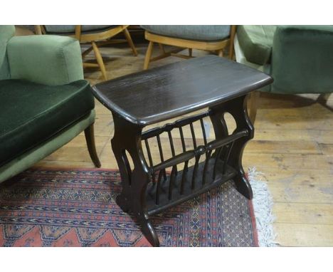 An Ercol dark elm occasional table/magazine rack, raised on shaped pierced side supports (h. 49cm)