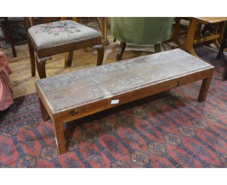 An Edwardian oak fender stool, with inset rectangular panelled seat on square supports. 30cm by 120cm by 39cm