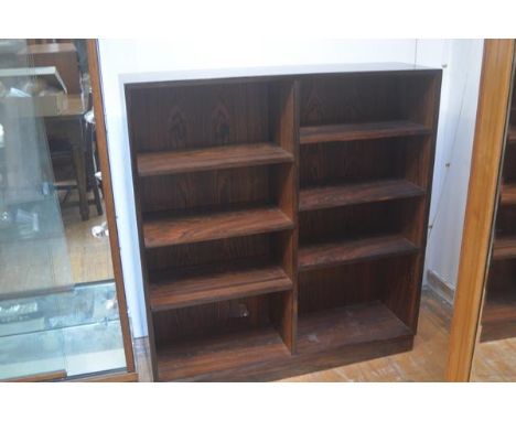 A 1970s rosewood veneered upright two section adjustable shelf bookcase on plinth base (h.119cm x l. 110cm x d.29cm) (back pa