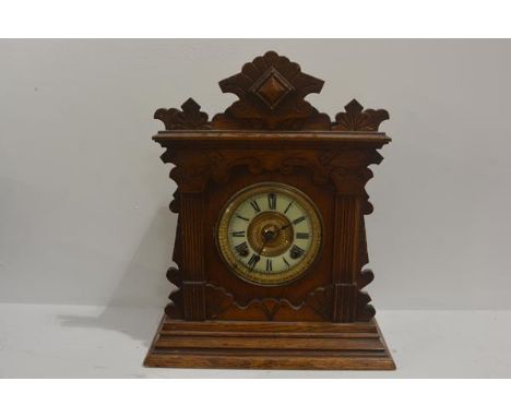 An Edwardian oak mantel clock with enamel dial, pedimented top. 41cm by 35cm by 14cm