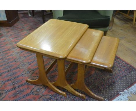 A light elm nest of three Ercol coffee tables raised on shaped end supports and splay feet (tallest: 44cm x 58cm x 43cm)