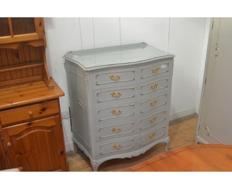 A vintage French green painted and gilt serpentine ledge back chest of drawers, with five long drawers, applied panel sides, 