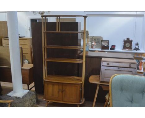 An Ercol light elm room divider with two adjustable shelves and one fixed top shelf above a pair of panel doors with twin end