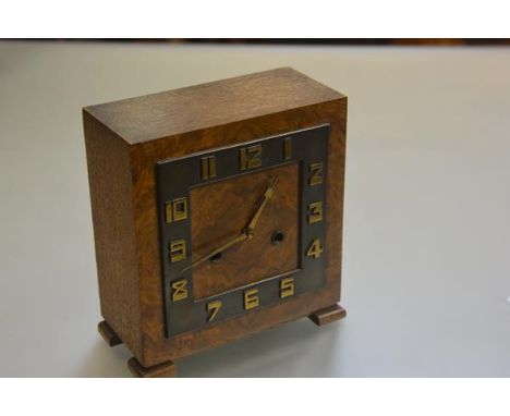 An Art Deco walnut square clock with arabic numerals and twin key apertures, raised on bracket feet, complete with pendulum a