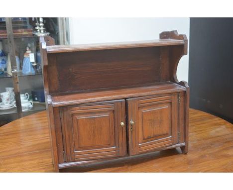 An Edwardian stained walnut wall cabinet with open shelf to top and two panelled doors. 54cm by 57cm by 18cm