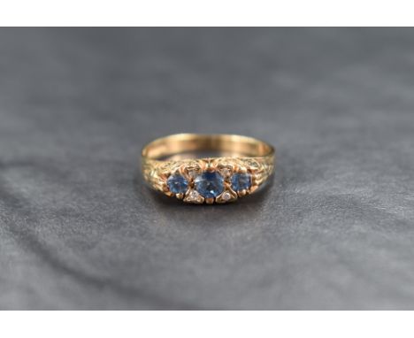 A 9ct gold sapphire and diamond ring, the three round cut graduated sapphires measuring between approximately 0.20ct to 0.10c