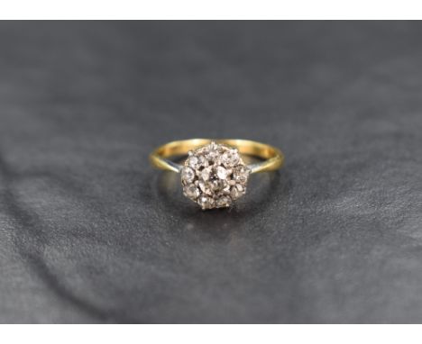 A diamond cushion cluster ring, approx 0.7ct total in a claw set mount to knife blade shoulders on a yellow metal loop stampe