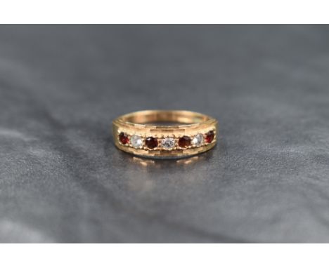A 9ct gold seven stone garnet and cubic zirconia band ring having cut detail to mount, ring size P and approximately 2.1g
