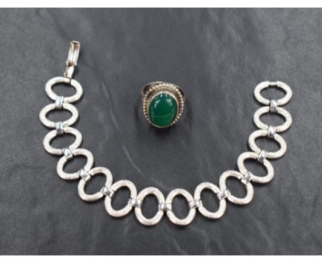 A silver bracelet having fourteen oval links with cut detail and link connectors, approx 190mm &amp; 32g and a white metal ri
