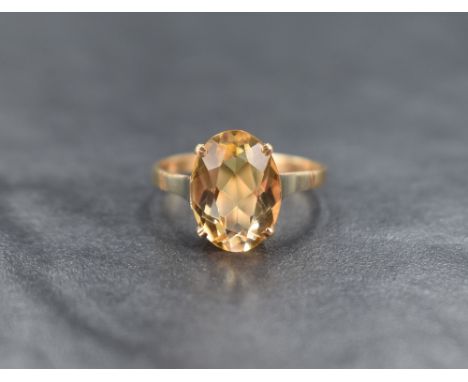 A 9ct gold citrine solitaire ring, the oval cut citrine measuring approximately 12.5mm x 9mm x 6.5mm in a four claw setting, 
