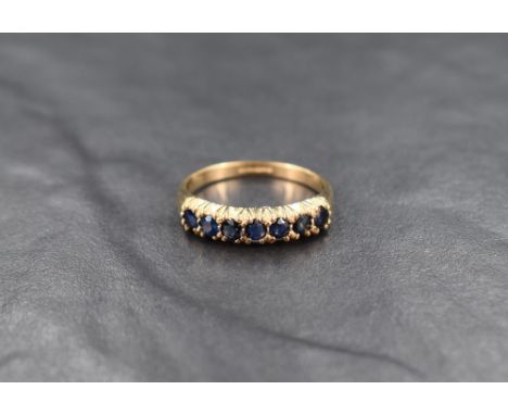 A 9ct gold sapphire half eternity band, the seven round cut sapphire in claw settings, ring size P-Q, 2.3g