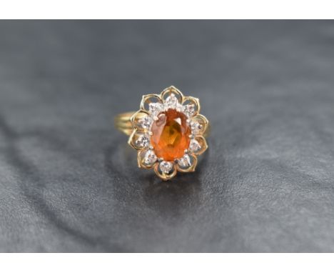 A 14ct gold citrine and diamond cluster ring, the central oval cut citrine with a ten diamond surround within an openwork flo