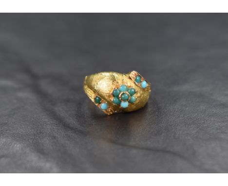 A yellow metal ring of domed form having a small turquiose cabochon posy cluster on a brushed surface with turquoise set, off