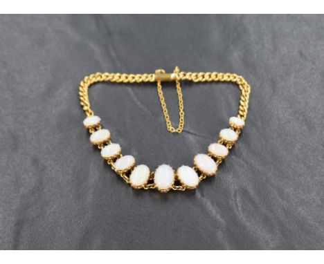 An 18ct gold opal bracelet, the eleven graduated oval cabochon opals in claw settings on an 18ct curb link bracelet with safe