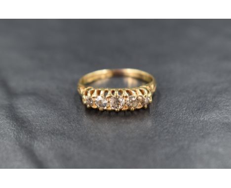 An 18ct gold and diamond five stone ring, the graduated diamonds measuring approximately 0.10ct to 0.03ct, having decorative 