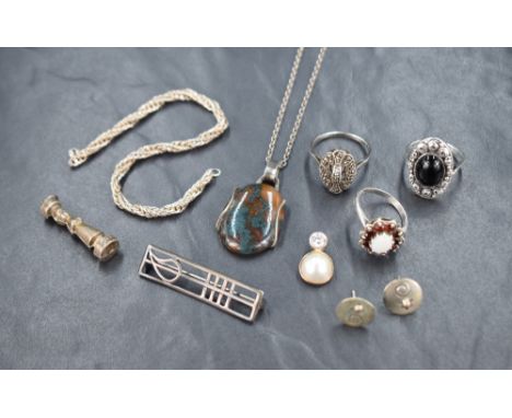 An assortment of silver jewellery, including an opal and garnet ring, a Rennie Mackintosh inspired brooch, stud earrings and 
