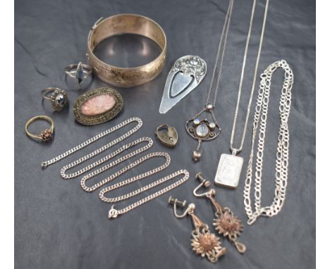 An assortment of silver and white metal jewellery, including a silver bangle with scroll engraving, an Art Nouveau style whit