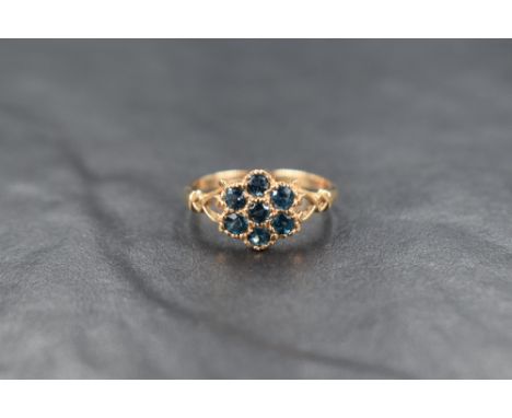 A 9ct gold blue topaz cluster ring, the seven round cut topaz in a floral motif cluster, having pierced shoulders, ring size 