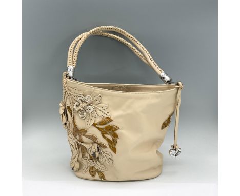 Light tan leather handbag decorated with individual sewn on tan flowers and patent amber leaves. Interior zipped section with