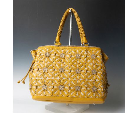 Large tan canvas with amber leather filigree overlay in a floral design, silver accents. Interior zippered middle section and
