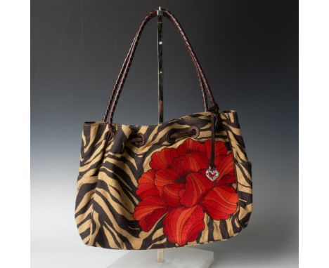 Tan and brown canvas in an animal print decorated with large red/orange flower, dark brown leather trim and shoulder straps. 