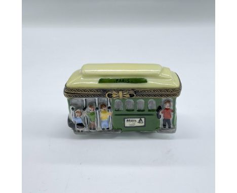 Hand painted porcelain treasure box with bronze tone hinged hardware modelled as a green city trolley with people seen holdin