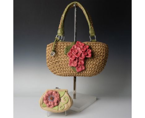 Straw handbag with interior pockets and zippered middle section with fold over green and pink leather closure in a flower and
