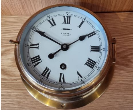 A ship's brass bulkhead clock by Sevill of Liverpool. England, with 8 day movement. 20cm diameter. 