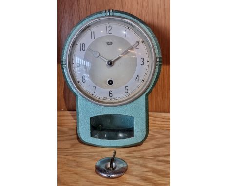 A 1950s Art Deco style Smiths Enfield wall clock, the painted cast aluminum case with silvered dial and Arabic numerals, mark