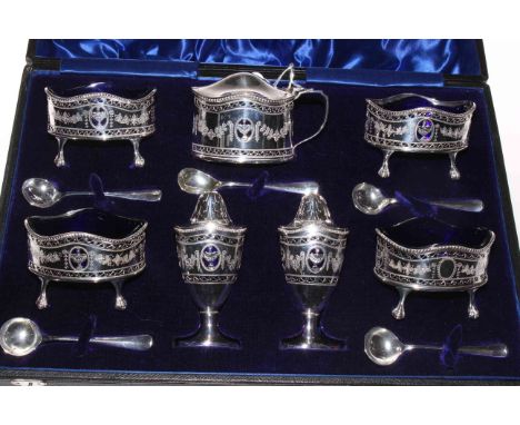 Cased silver seven piece cruet set plus five spoons, Birmingham 1910/11, each elegant piece with pierced and engraved decorat