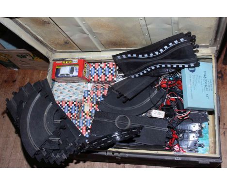 Vintage tin trunk containing Scalextric accessories.