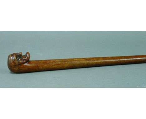 A 19th century 'folk art' walking stick, the carved man's head with prominent chin, 90cm long