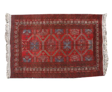 (WH) An Afghan Belouch rug, with four central step medallions to a red ground within multiple borders, 190 x 120cm