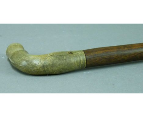 An early 20th century hardwood walking stick, with rhino horn handle carved as a hoof, 90cm long