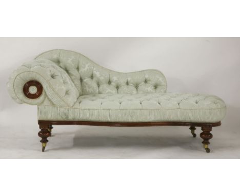 A Victorian large chaise longue, the scrolled end with light green button back upholstery, with turned legs on brass castors,