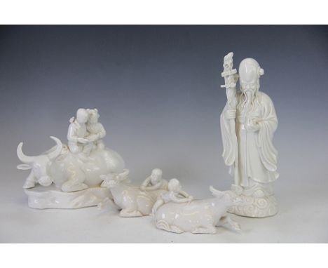 A group of four Chinese blanc de chine figures, to include; two 'Boy and a buffalo' examples, 15cm wide, a sage modelled stan