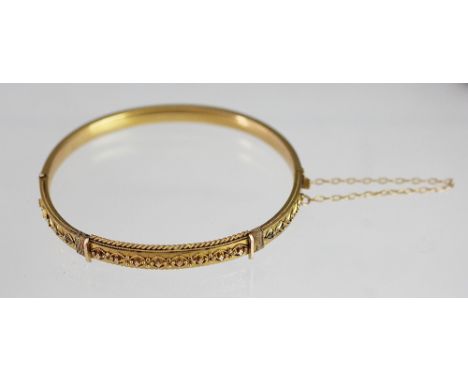A Victorian 15ct yellow gold bangle, the hinged bangle with half wirework decoration and attached safety chain, weight 10.2gm